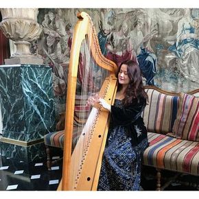 Arianna Savall grająca na harfie w zabytkowym pomieszczeniu